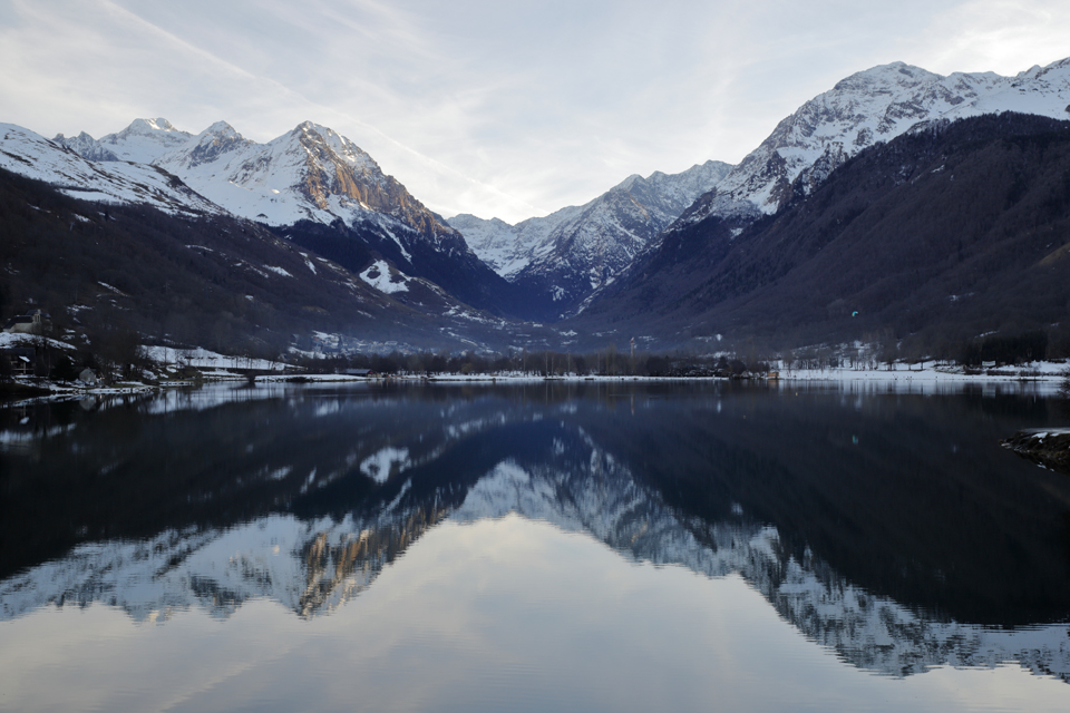 Photo d’un lac entouré de montagnes aux sommets enneigés