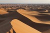 Photographie, prise en fin d’après-midi, de dunes de sable dans le désert marocain, aux portes du Sahara